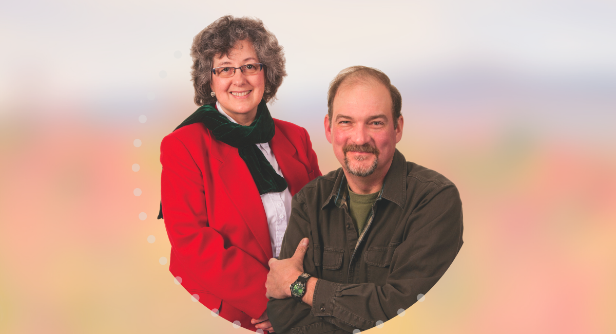 Dr. Fay Migotsky, dressed in a red blazer, stands smiling beside her patient, Mark Stevens, who is seated and wearing a green shirt. Both are looking at the camera, showing a sense of warmth and trust in their doctor-patient relationship. The background is softly blurred with warm tones