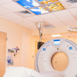 A modern MRI machine is shown in a clean and well-lit imaging room, emphasizing advanced medical technology and patient care