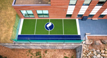 outdoor physical therapy space with green turf and mch logo in the middle