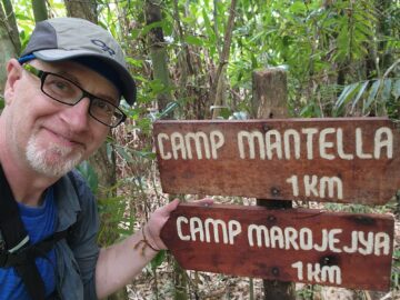 Dr Harrington with signs for Camp Mantella and Camp Marojejya