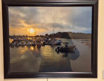 A cloudy sunset with small boats in the harbor