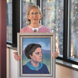 Karen Clement holding a painting of her grandmother, Margaret Adams Clement