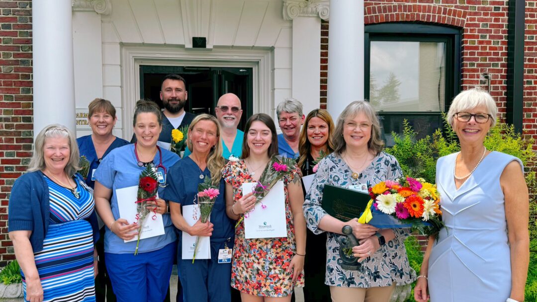 DAISY Award nominees and winner as well as MCH Executive Team staff A group of healthcare professionals standing outside a brick building with white columns. They are smiling and holding flowers and certificates, celebrating an achievement. There is a mix of nurses and administrative staff in the group