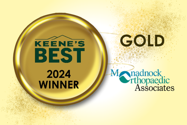 A gold circular emblem on a pale yellow background, featuring the text "Keene’s Best 2024 Winner" in green within the circle. To the right, the word "Gold" is displayed in large, bold letters. The emblem is connected with a line to the Monadnock Orthopaedic Associates logo, which includes the name "Monadnock Orthopaedic Associates" with a stylized design of a curved line intersecting the text in teal