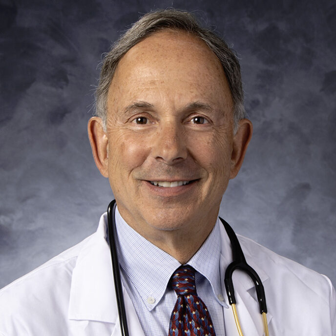 A professional headshot of Dr. Jonathan Krant, a distinguished male doctor wearing a white lab coat, dress shirt, patterned tie, and stethoscope around his neck, smiling against a neutral background