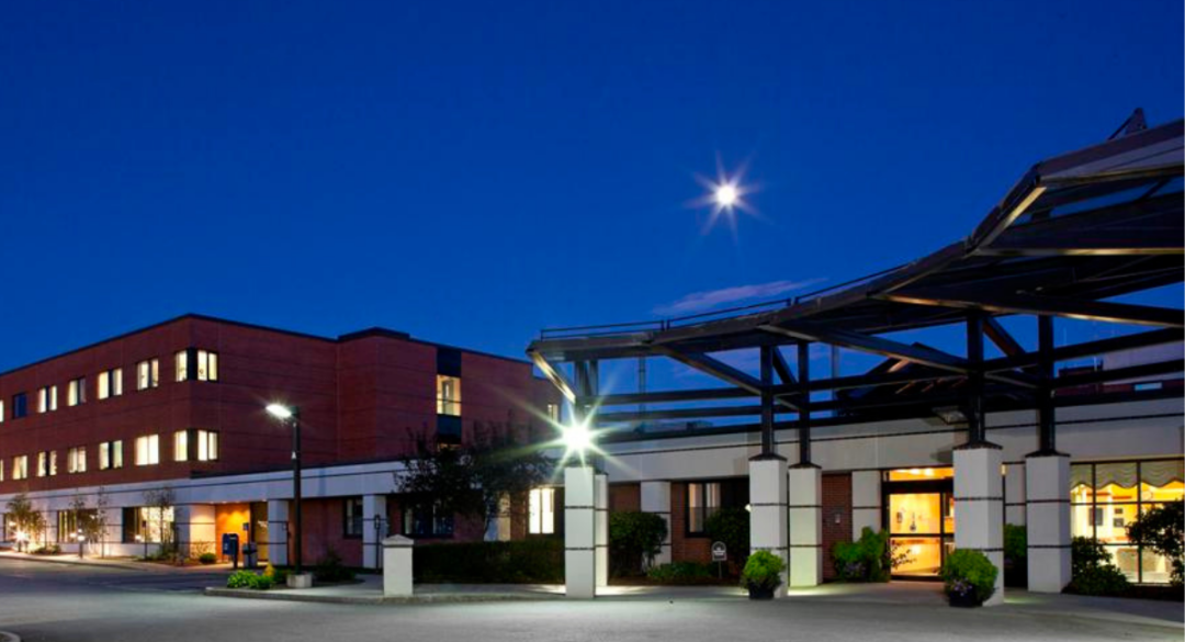 Hospital building with an entrance and night lighting under a full moon