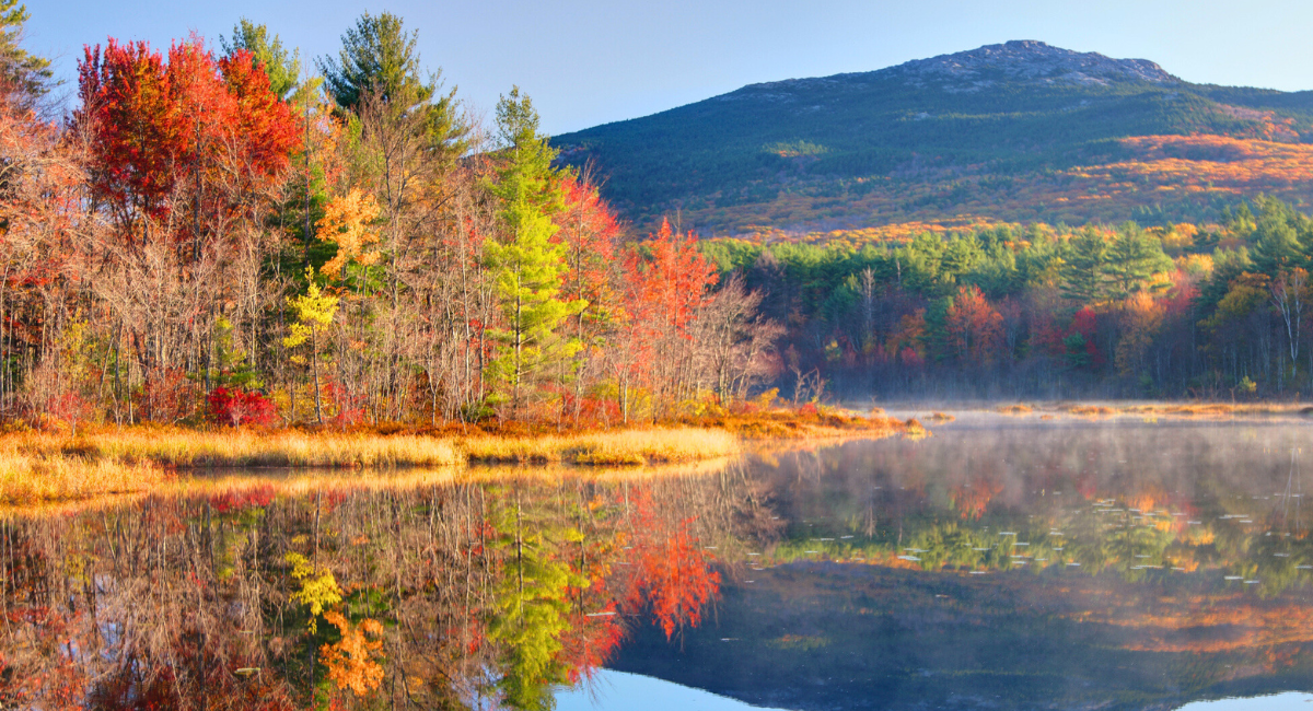 Mount Monadnock with extensive fall foliage reflected in a large lake