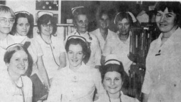 A historical black-and-white photo of a group of nurses at Monadnock Community Hospital, all dressed in traditional nursing uniforms, smiling for the camera.