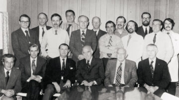 A black-and-white group photo of physicians from Monadnock Community Hospital taken in 1974, with some seated and others standing, all dressed in formal attire or medical coats.