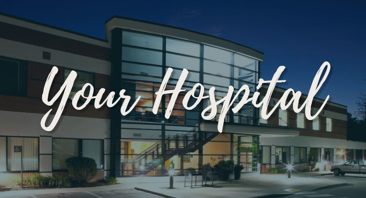 A nighttime view of Monadnock Community Hospital's entrance, featuring a modern glass facade illuminated with warm interior lights. The words 'Your Hospital' are prominently displayed in elegant script across the image, symbolizing the hospital's welcoming and community-focused approach.