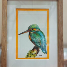 Framed painting of a kingfisher with brilliant blue and green feathers, perched on a branch, presented with an orange border, emphasizing the bird's vivid colors.