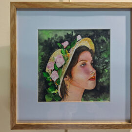 Framed watercolor portrait of a woman in profile wearing a straw hat adorned with pink roses. The background is a lush green, emphasizing the serene and contemplative expression on her face