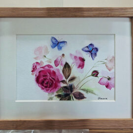 Watercolor painting of a floral arrangement with pink roses and two delicate blue butterflies. The artwork captures the soft colors and gentle beauty of the flowers and butterflies in a wooden frame