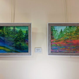 Two paintings side by side, both framed in light wood: the left features a serene, evergreen forest with a deep blue and green color palette, and the right shows a vibrant forest with a bright red and green landscape, evoking a sense of motion and color.