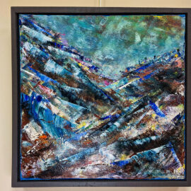 An abstract painting featuring dynamic, layered brushstrokes in shades of blue, brown, and white, creating a sense of movement and depth. The artwork is rich in texture, conveying a rugged, mountainous landscape. The painting is framed in a black frame and hung on a beige wall, with a label indicating its title and artist