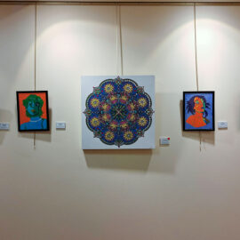 A collection of five framed artworks on a wall at Monadnock Community Hospital. The artworks include colorful abstract portraits and a large, intricate mandala design in the center