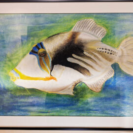 A colored pencil drawing by Leon Brassard of a Picasso triggerfish. The fish is depicted with its distinctive patterns and colors, set against a backdrop of soft blues and greens, capturing its vibrant and exotic appearance