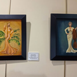 Two framed paintings displayed side by side on a wall. The left painting shows a woman in a golden gown surrounded by palm fronds, exuding vintage elegance. The right painting features a woman in a sophisticated white gown with a fur wrap, posed confidently against a dark background. Both artworks convey a sense of classic glamour and styl