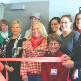 A group of community members and officials smiling as they cut a red ribbon to inaugurate the new prescription drug take-back box at the Peterborough Police Department