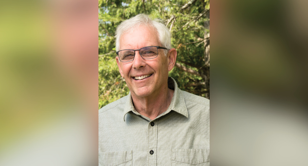 Peter Russell, smiling outdoors in a natural setting, recovering from knee replacement surgery, and enjoying an active lifestyle again.