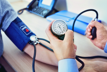 A healthcare professional measuring a patient's blood pressure, highlighting access to vascular specialists for comprehensive care in Peterborough, NH