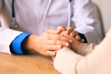 A clinician holds the hands of a patient