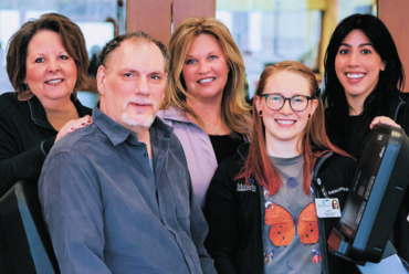 A grateful patient poses with a group of smiling rehabilitation professionals