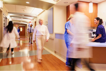 A busy hospital hallway with people walking by