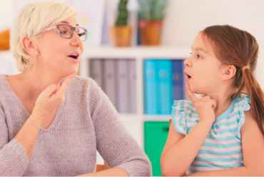 A speech therapist working with a young child, highlighting speech and language pathology services at Monadnock Community Hospital