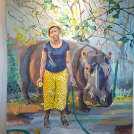 A painting featuring a woman standing beside a hippo. The woman is dressed in bright yellow pants and a hat, while the hippo stands calmly beside her, surrounded by abstract foliage with letters floating in the background.