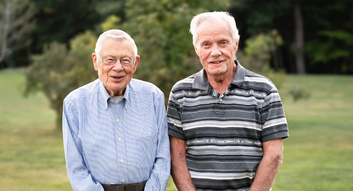 Norm Makechnie and Brad Farnham, MCH volunteers, smiling outdoors as they celebrate their 90th birthdays