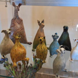 A display of various ceramic animals with unique textures and shapes, each figure showing individual character and artistry.