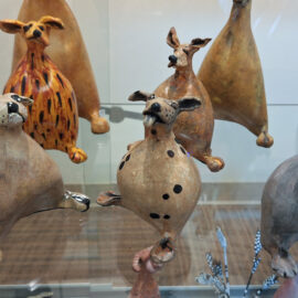 A display of various ceramic animals with unique textures and shapes, each figure showing individual character and artistry.