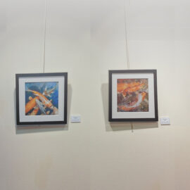 Framed artwork of several koi fish in shades of orange and white, swimming in deep blue water with realistic textures.