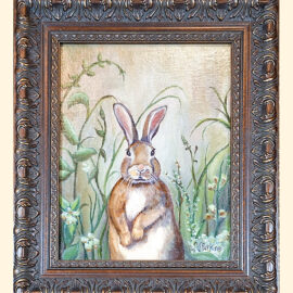 A charming framed painting of a rabbit standing upright among tall grasses and delicate flowers, surrounded by a decorative wooden frame.