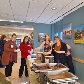 Team members in the hospital cafeteria serving ice cream during the Employee Giving Campaign, fostering a spirit of giving and camaraderie