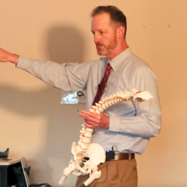 Dr McNamara uses a spine model to demonstrate advanced concepts in orthopedic care, focusing on patient education