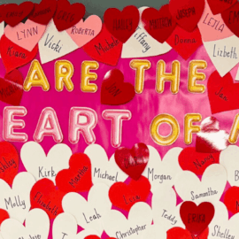A vibrant appreciation display at Monadnock Community Hospital featuring the message "You Are the Heart of MCH" in bold letters, surrounded by red and white heart-shaped cutouts with employee names written on them.