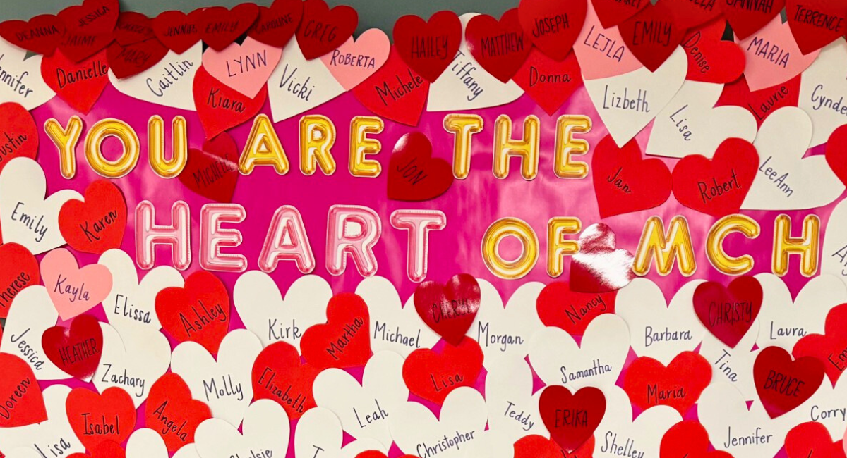 A vibrant appreciation display at Monadnock Community Hospital featuring the message "You Are the Heart of MCH" in bold letters, surrounded by red and white heart-shaped cutouts with employee names written on them.