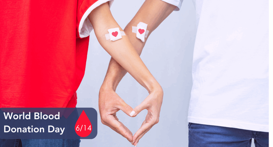 Two people link arms to form a heart shape with their hands. Both have bandages with red heart stickers on their arms, indicating recent blood donations. A red droplet graphic displays the text: "World Blood Donation Day – 6/14."