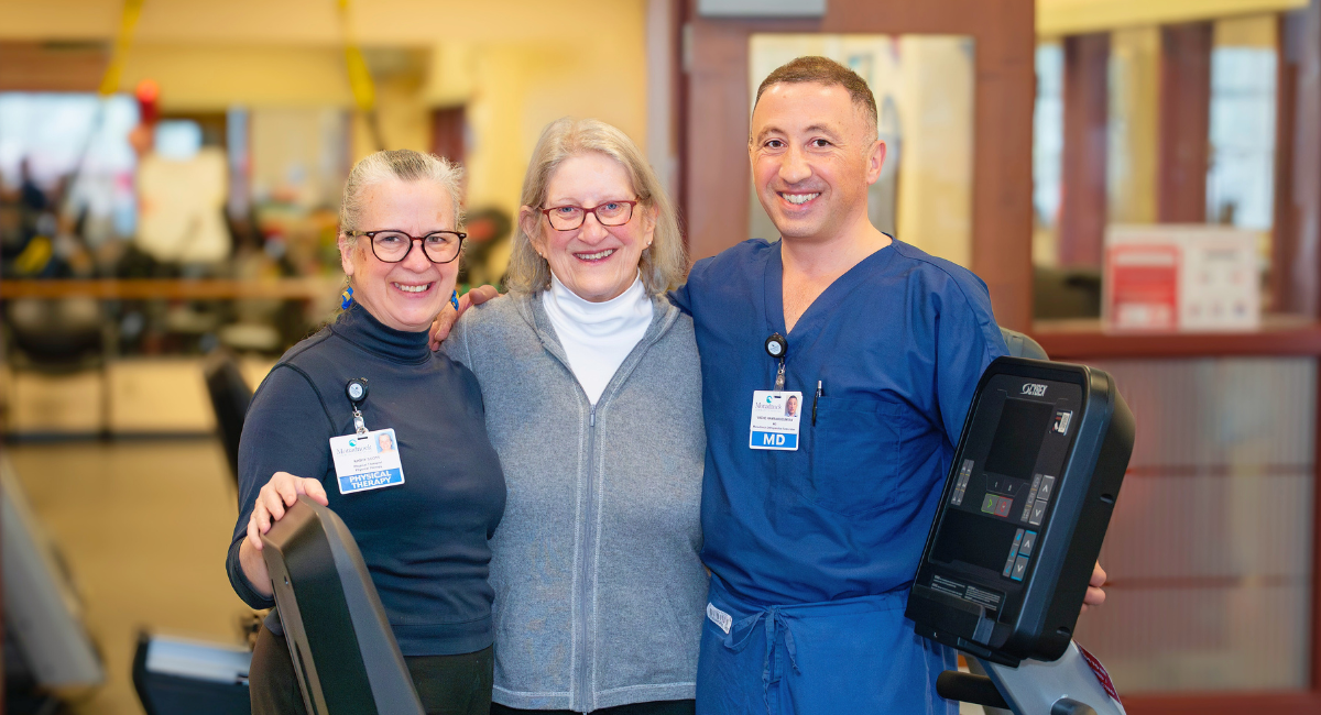 Rosamond Cady stands smiling between physical therapist Kathy Scott and orthopedic surgeon Dr. Vache Hambardzumyan in the Monadnock Community Hospital rehab space, celebrating her recovery journey with the team that helped her heal.