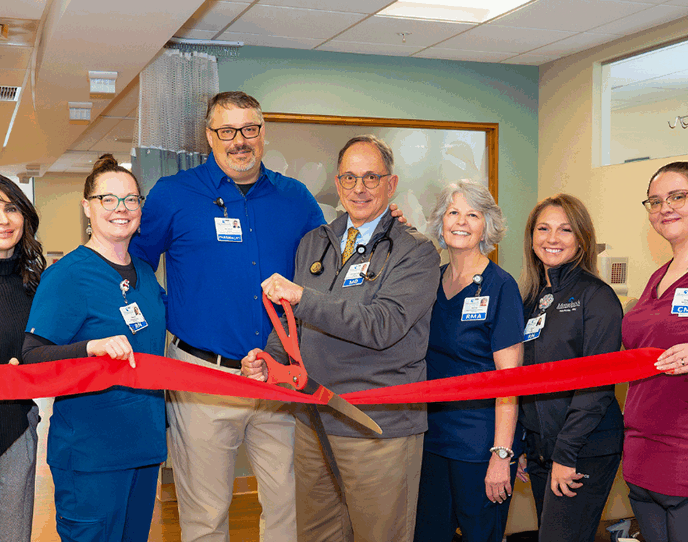 Dr. Jonathan Krant and the Monadnock Rheumatology Associates team stand together inside a clinical space with a red ribbon, marking their practice launch.