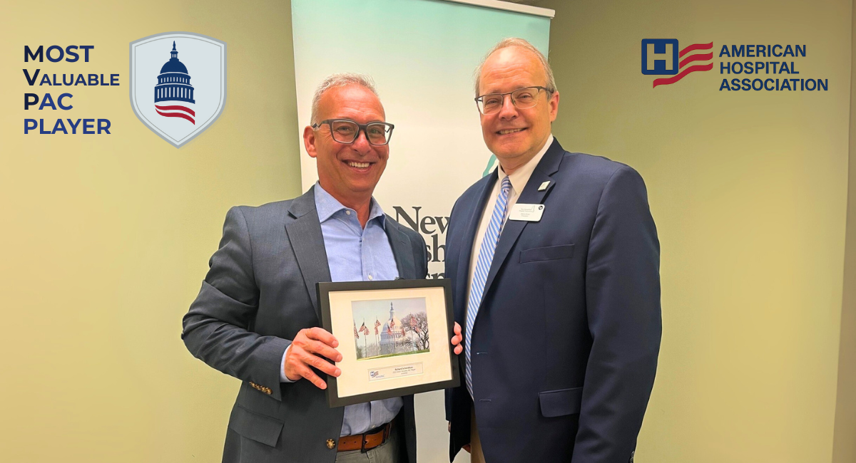 Richard Scheinblum, left, receives the 2025 Most Valuable PAC Player award from the American Hospital Association. He is pictured holding a framed certificate and standing next to Steve Ahnen, President of the New Hampshire Hospital Association, in front of an NHHA banner.