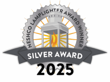 Official NESHCo Lamplighter Award badge featuring a glowing lantern with rays, a black and silver ribbon reading “Silver Award,” and the year “2025” displayed below.