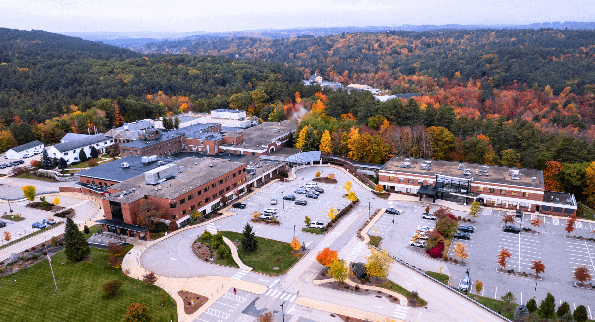 Aerial view of Monadnock Community Hospital in autumn, with colorful foliage surrounding the medical campus and nearby roads and parking areas visible in the foreground.