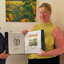 Toni Gildone, Liz Keeney, and Caroline Gomez proudly present the Art a La Carte binder at Monadnock Community Hospital. Part of the Healing Arts initiative, this new program allows patients in the Medical Surgical Unit to choose personalized artwork for their rooms—bringing comfort, choice, and beauty to the bedside.