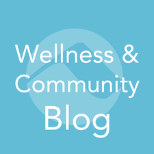 Light blue square button with the words ‘Wellness & Community Blog’ over a stylized mountain icon