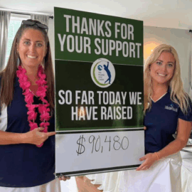 Two Monadnock Community Hospital staff smile while holding a large sign that reads, “Thanks for your support – So far today we have raised $90,480.”