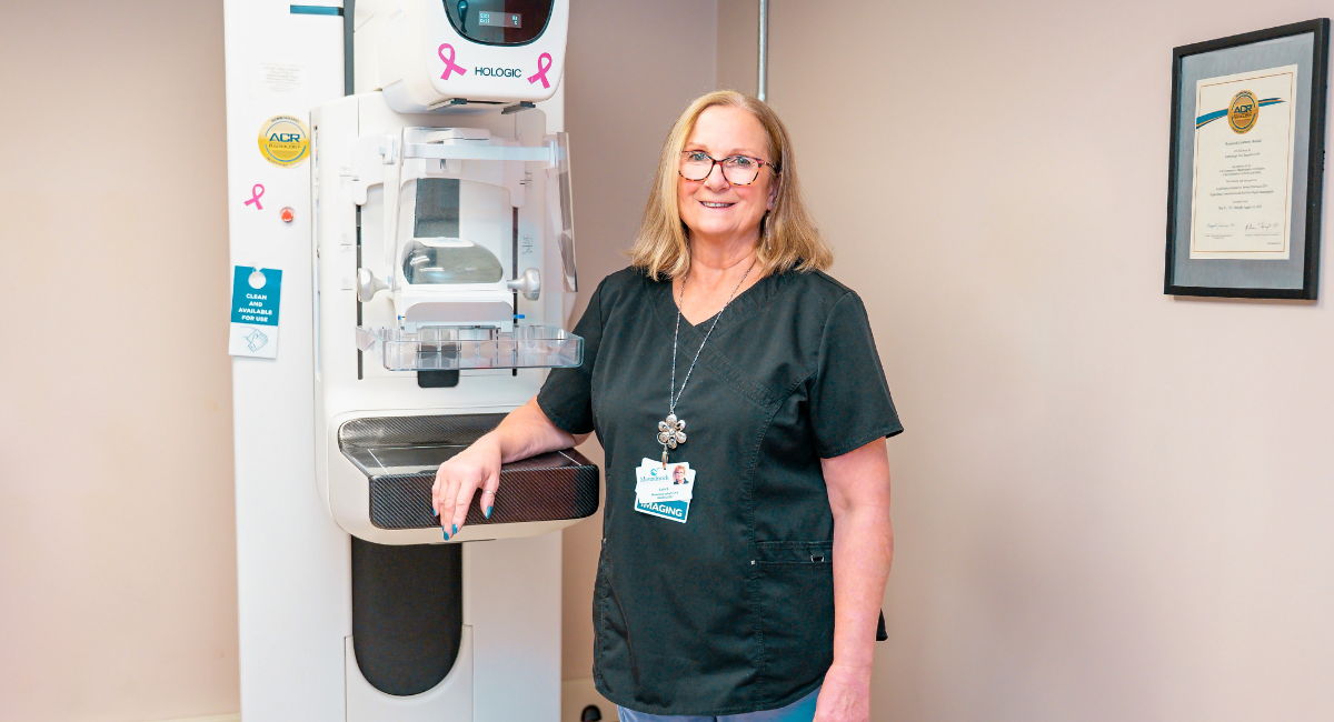 Lois Steinmann, Mammography Technologist at Monadnock Community Hospital, stands beside a 3D mammography machine in the Women’s Imaging Center.