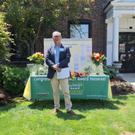 Richard Scheinblum, President and CEO of Monadnock Community Hospital, stands in front of the DAISY Award display and ceremony setup outside the hospital.